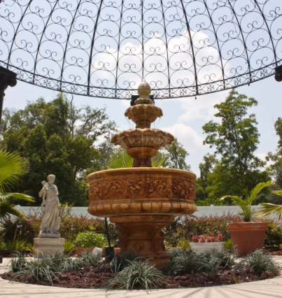 An ornate fountain in the middle of a garden.